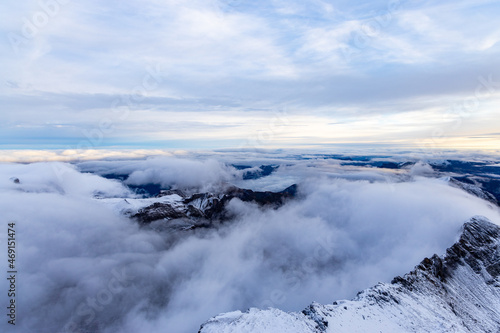 View from the summit of mountain Schilthorn in the Swiss Alps Switzerland at sunrise with dramatic clouds and fresh snow.