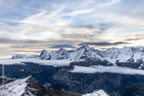 View of the famous peaks Jungfrau, Mönch and Eiger from the mountain Schilthorn in the Swiss Alps Switzerland at sunrise with dramatic clouds and fresh snow. © Donald Blodger