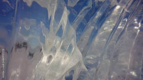 Polished glazed ice wall, viewing through clear blue frozen texture