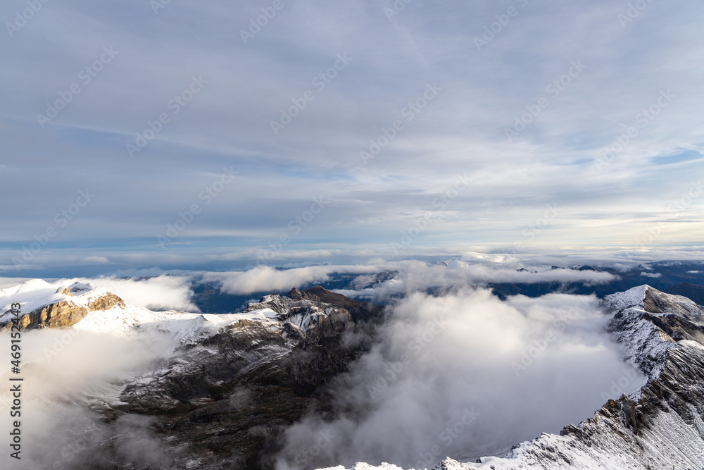 View from the summit of mountain Schilthorn in the Swiss Alps Switzerland at sunrise with dramatic clouds and fresh snow. View from the summit of mountain Schilthorn in the Swiss Alps Switzerland at sunrise with dramatic clouds and fresh snow.