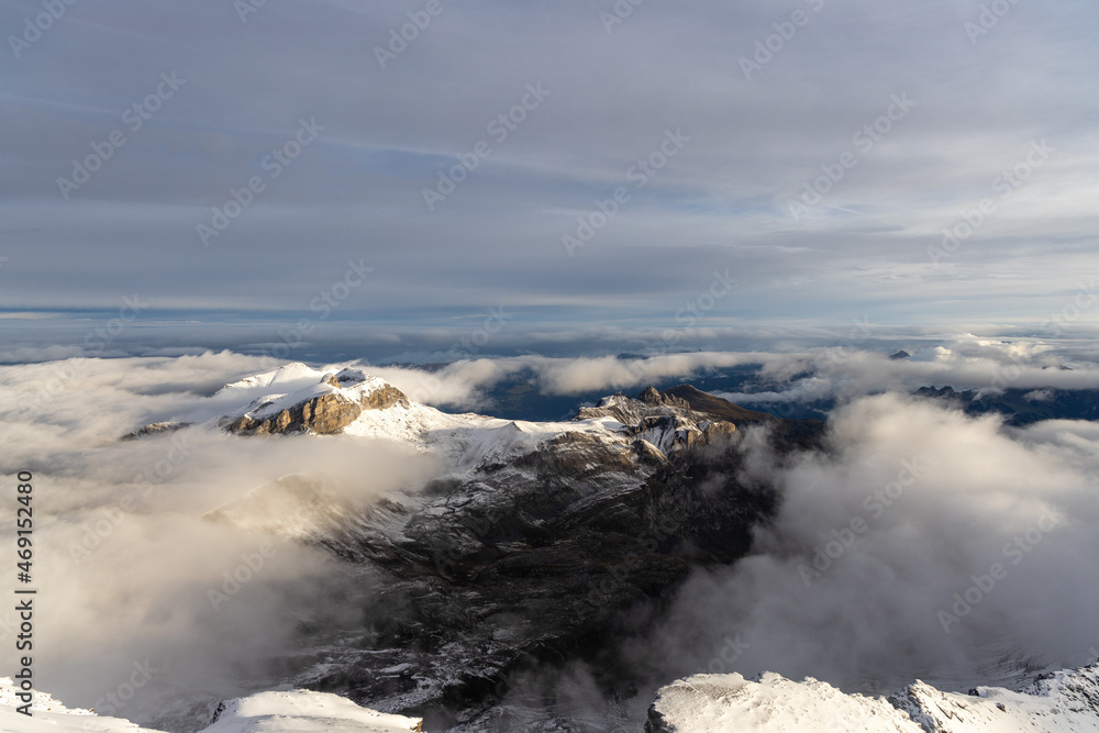 View from the summit of mountain Schilthorn in the Swiss Alps Switzerland at sunrise with dramatic clouds and fresh snow.