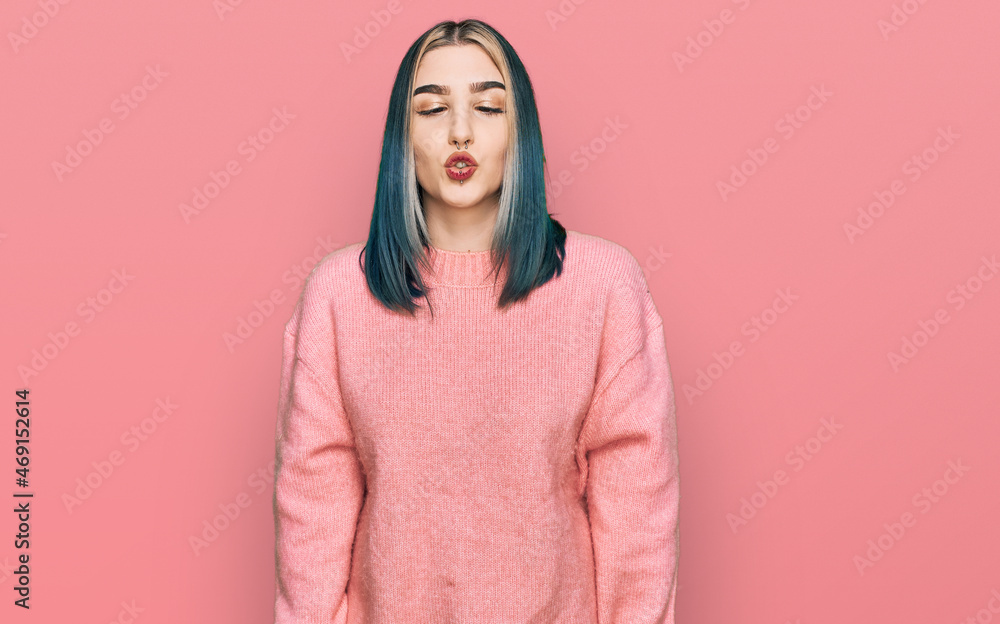 Young modern girl wearing pink wool winter sweater making fish face with lips, crazy and comical gesture. funny expression. Young modern girl wearing pink wool winter sweater making fish face with lips, crazy and comical gesture. funny expression.