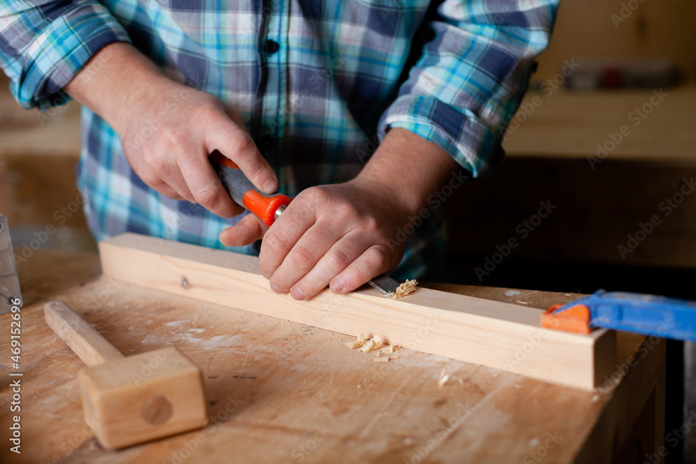 A carpenter in a plaid shirt works a workshop. Wood. Ecological compatibility. Lifestyle. Close up. A carpenter in a plaid shirt works a workshop. Wood. Ecological compatibility. Lifestyle. Close up.
