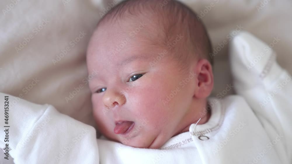 Lovely newborn baby portrait. Face of an infant baby laying on a bed. Hungry little child looking for mother. Cute little child. Lovely newborn baby portrait. Face of an infant baby laying on a bed. Hungry little child looking for mother. Cute little child.