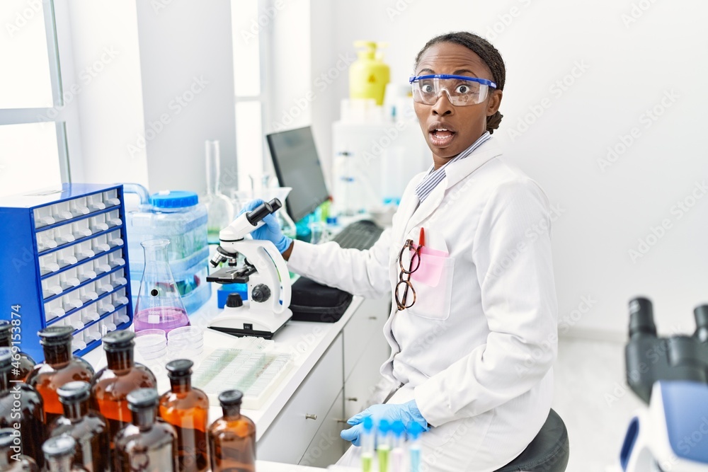 African woman working at scientist laboratory scared and amazed with open mouth for surprise, disbelief face African woman working at scientist laboratory scared and amazed with open mouth for surprise, disbelief face