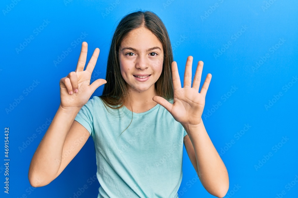 Beautiful brunette little girl wearing casual white t shirt showing and pointing up with fingers number eight while smiling confident and happy. Beautiful brunette little girl wearing casual white t shirt showing and pointing up with fingers number eight while smiling confident and happy.