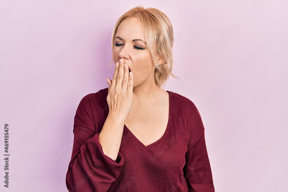 Young blonde woman wearing casual winter sweater bored yawning tired covering mouth with hand. restless and sleepiness. Young blonde woman wearing casual winter sweater bored yawning tired covering mouth with hand. restless and sleepiness.