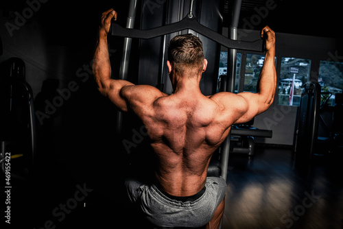 Junger Mann der seinen Rücken Im Fitnesscenter trainiert