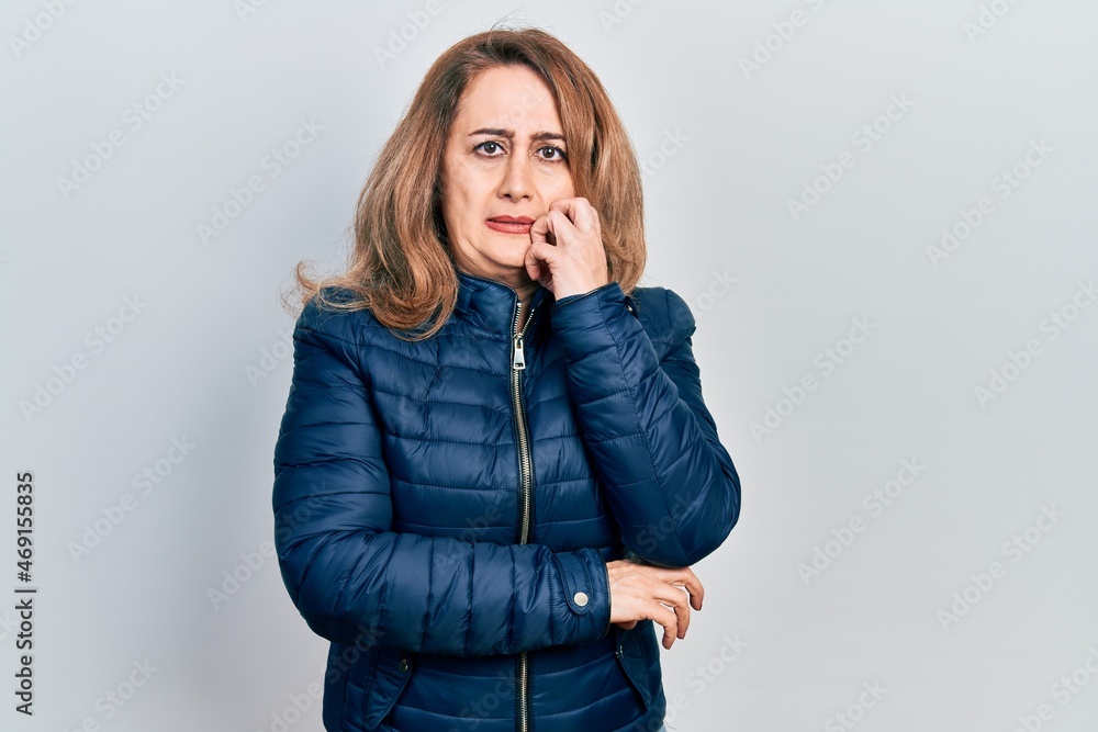 Middle age caucasian woman wearing casual clothes looking stressed and nervous with hands on mouth biting nails. anxiety problem. Middle age caucasian woman wearing casual clothes looking stressed and nervous with hands on mouth biting nails. anxiety problem.