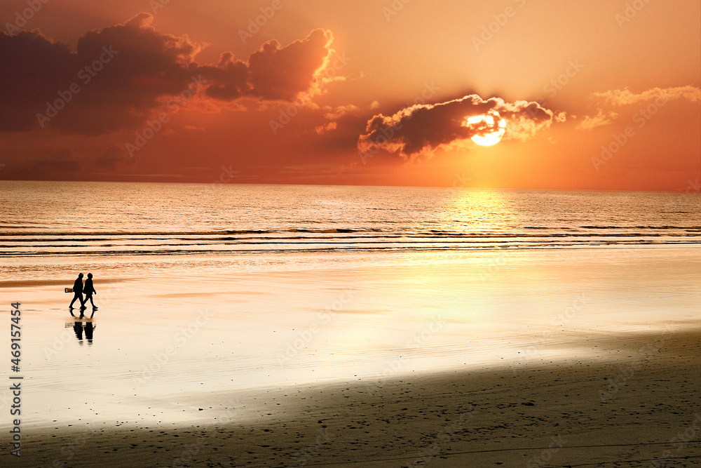Senioren Paar spaziert am Strand bei Sonnenuntergang am Meer - Atlantik.