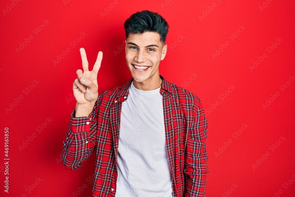 Young hispanic man wearing casual clothes showing and pointing up with fingers number two while smiling confident and happy. Young hispanic man wearing casual clothes showing and pointing up with fingers number two while smiling confident and happy.