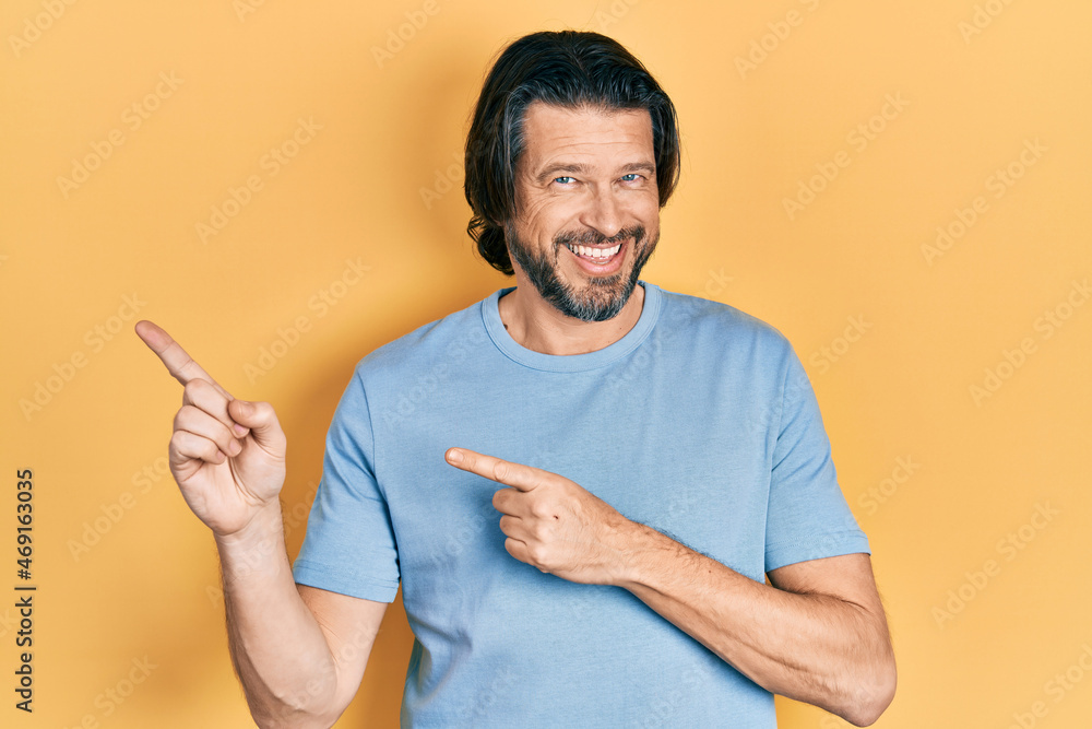 Middle age caucasian man wearing casual clothes smiling and looking at the camera pointing with two hands and fingers to the side. Middle age caucasian man wearing casual clothes smiling and looking at the camera pointing with two hands and fingers to the side.