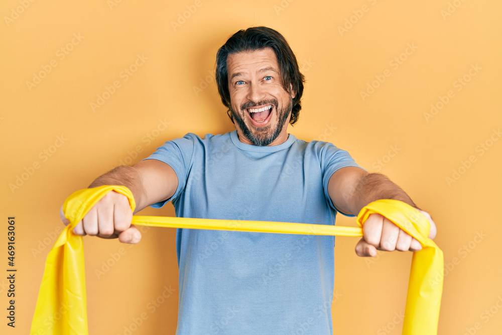 Middle age caucasian man wearing sportswear and arm elastic band celebrating crazy and amazed for success with open eyes screaming excited. Middle age caucasian man wearing sportswear and arm elastic band celebrating crazy and amazed for success with open eyes screaming excited.