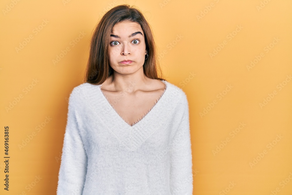 Young caucasian girl wearing casual clothes puffing cheeks with funny face. mouth inflated with air, crazy expression. Young caucasian girl wearing casual clothes puffing cheeks with funny face. mouth inflated with air, crazy expression.