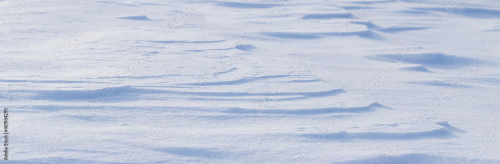 Snowy background, snow-covered surface of the earth after a blizzard in the morning in the sunlight with distinct layers of snow Snowy background, snow-covered surface of the earth after a blizzard in the morning in the sunlight with distinct layers of snow