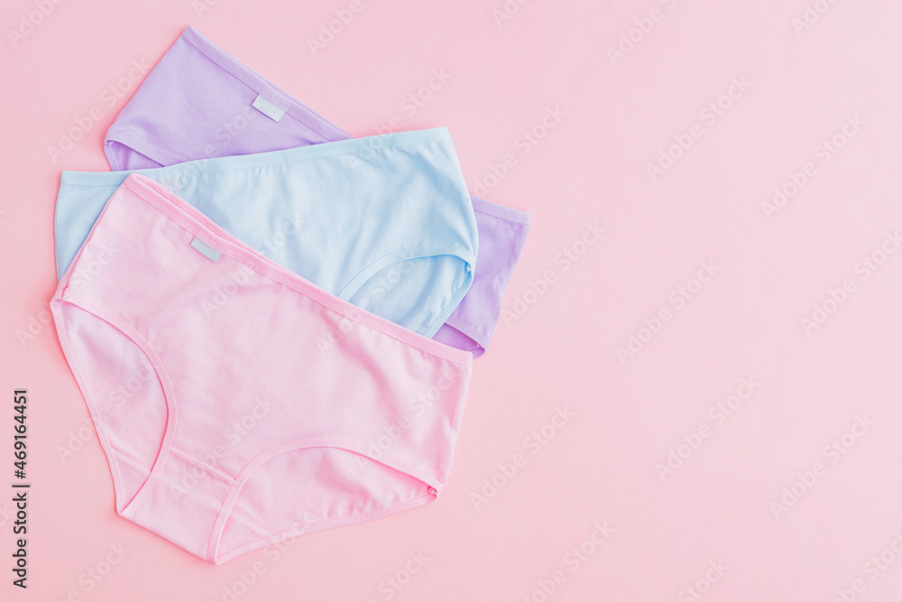 Flat lay set of women panties of different colors on a pink background. Top view advertising and shopping concept Flat lay set of women panties of different colors on a pink background. Top view advertising and shopping concept