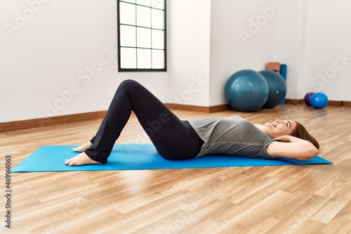 Middle age caucasian woman training abs exercise at sport center