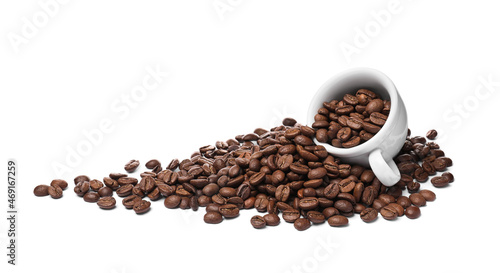 Overturned cup with roasted coffee beans on white background