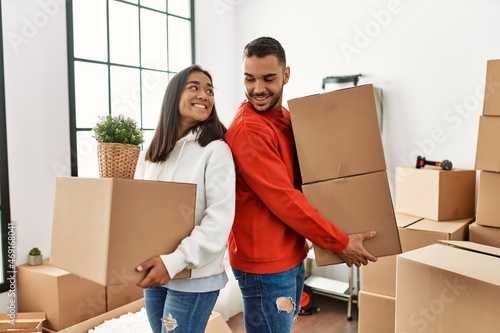 Young latin couple smiling happy holding cardboard box at new home. © Krakenimages.com