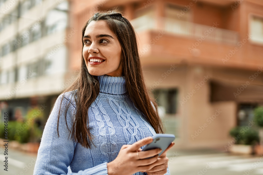 Young hispanic girl smiling happy using smartphone at the city Young hispanic girl smiling happy using smartphone at the city
