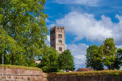 Lucca charming historical center. View of the iconic St Frediano medieval bell tower with ancient city walls