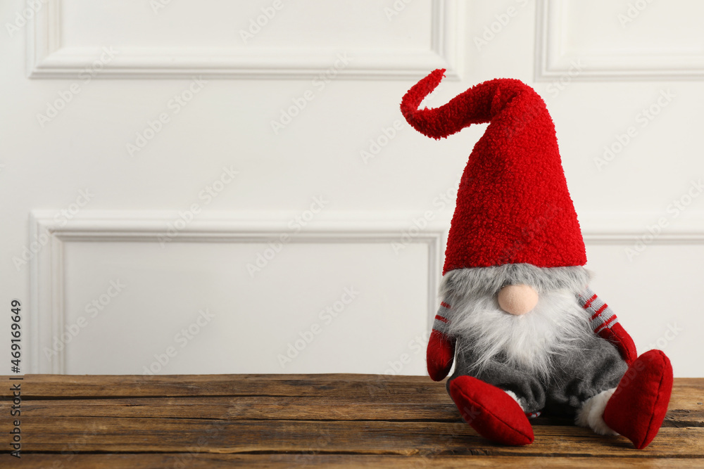 Obraz premium Cute Christmas gnome on wooden table. Space for text