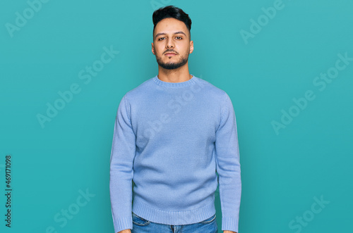 Young arab man wearing casual clothes with serious expression on face. simple and natural looking at the camera.