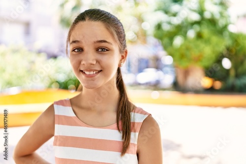 Young teenager girl outdoors on a sunny day looking positive and happy standing and smiling with a confident smile showing teeth