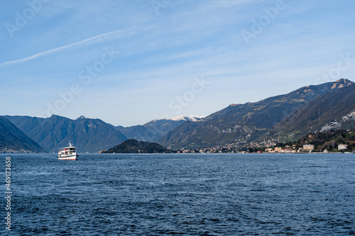 Ferry sails on Lake Como with mountains in the background © Nadtochiy