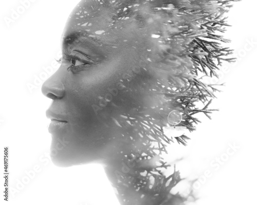 A double exposure black and white portrait of a young woman combined with coniferous plant.