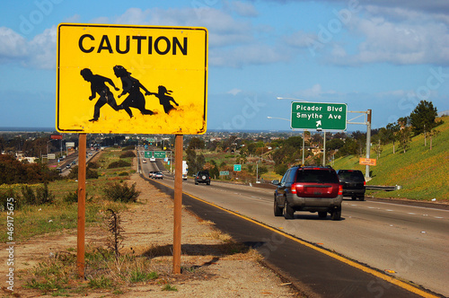 A sign on the highway near San Diego, California warns drivers to beware of immigrants and migrants crossing the busy freeway photo