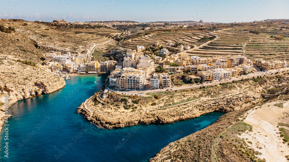 Aerial view of Xlendi, a picturesque village in Gozo island, Malta, surrounded by steep cliffs and valleys.Xlendi Bay is popular swimming,sunbathing and diving spot with small sandy beach.Holiday