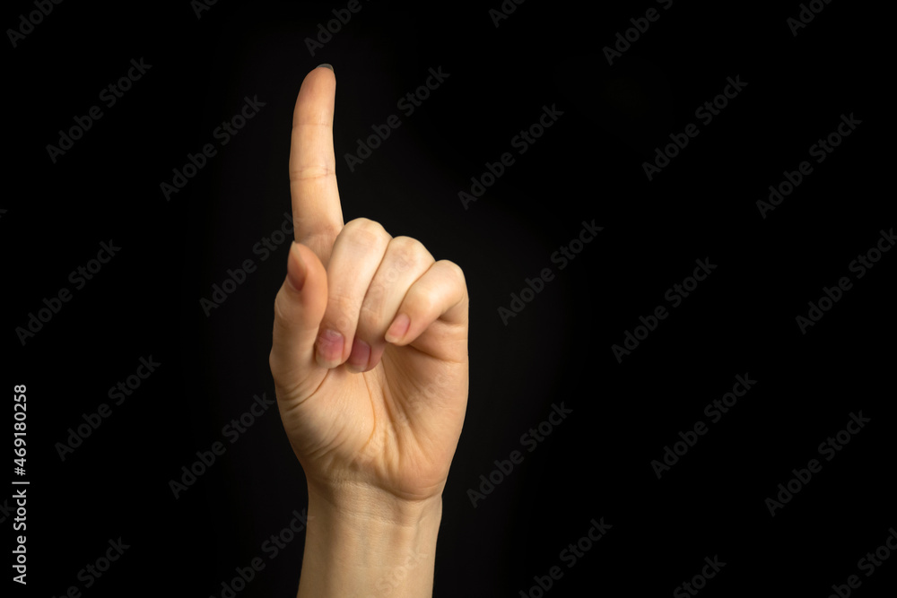 Hand point up. Woman hand gesture, pointing sign, gesture look at this, pay attention. Black background photo Hand point up. Woman hand gesture, pointing sign, gesture look at this, pay attention. Black background photo