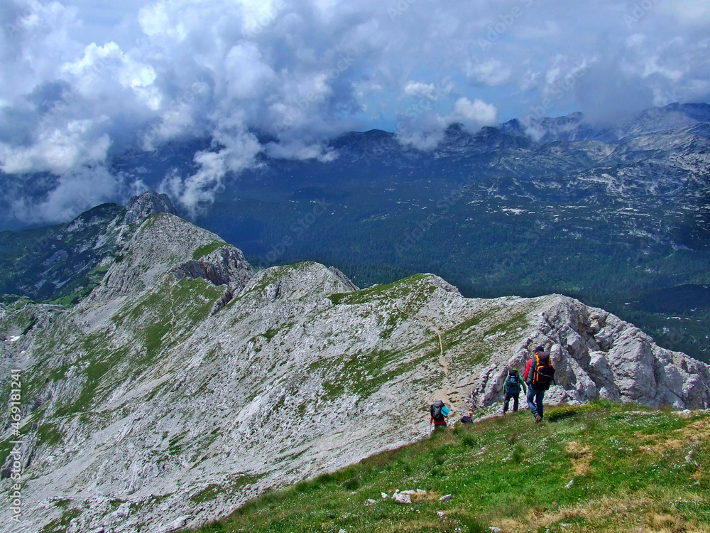 group of tourists climbing mountain overlooking clouds. People like adventure