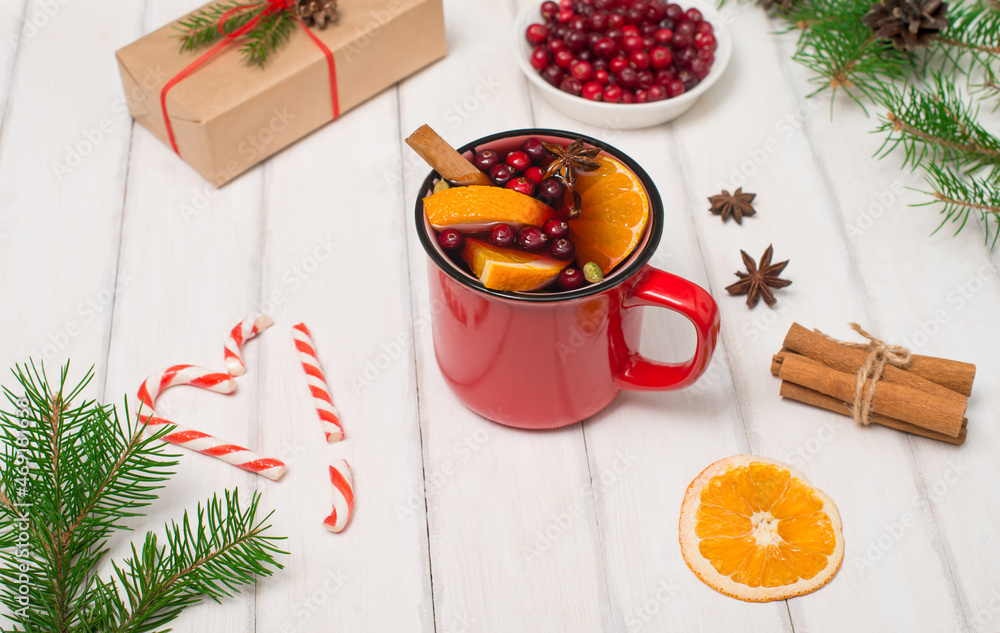 Christmas white wooden background with mulled wine in red mug, Christmas gift box, anise and spruce branches. Side view selective focus. Christmas white wooden background with mulled wine in red mug, Christmas gift box, anise and spruce branches. Side view selective focus.