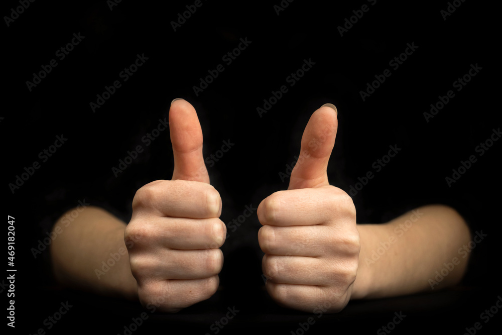 Business gesture. Thumb up close-up. Black background with copy space Business gesture. Thumb up close-up. Black background with copy space