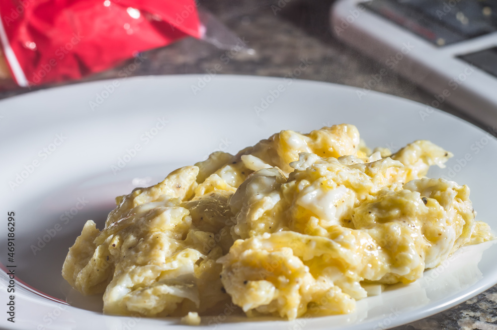 scrambled eggs on a white plate with copy space