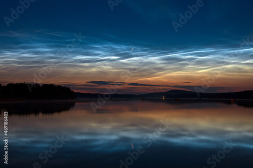 Noctilucent clouds and Perseid meteor at night sky