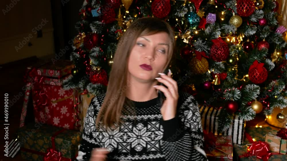 Young asian woman calling in christmas eve in front of christmas tree. High quality 4k footage Young asian woman calling in christmas eve in front of christmas tree. High quality 4k footage
