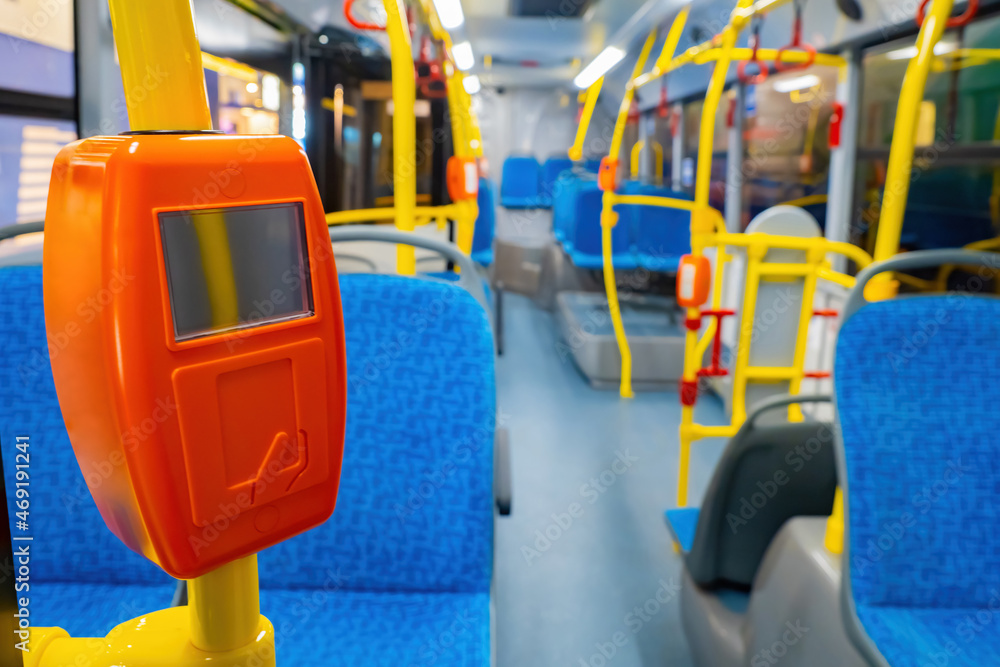 Bus handrails with validator. Payment acceptance validator. Equipment for payment by travel card. NFC payment acceptance system. Interior of modern bus. NFC fare validator. Selective blurred