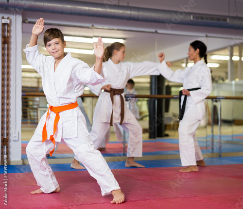 Portrait of a teenage boy in kimono posing during karate class at gym