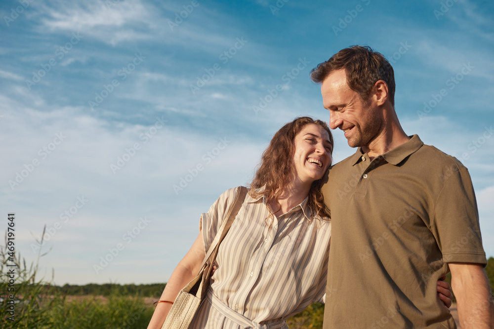 Waist up portrait of happy couple in nature against blue sky, copy space Waist up portrait of happy couple in nature against blue sky, copy space