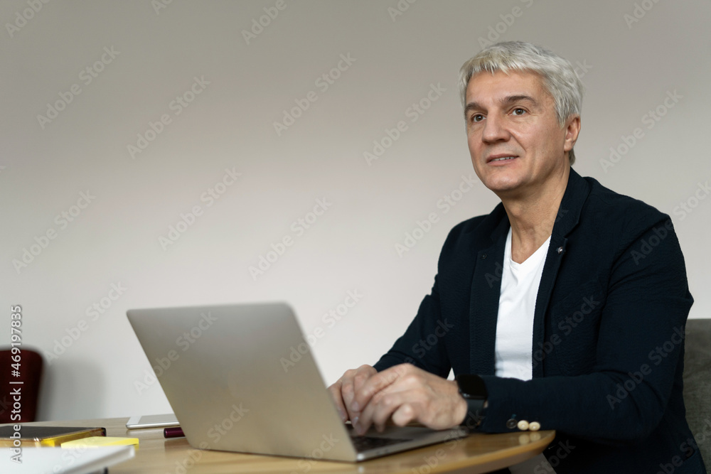 Workplace in coworking. Man online surf the internet. Financier gray makes a financial report in the company. The age manager works in the office. Workplace in coworking. Man online surf the internet. Financier gray makes a financial report in the company. The age manager works in the office.