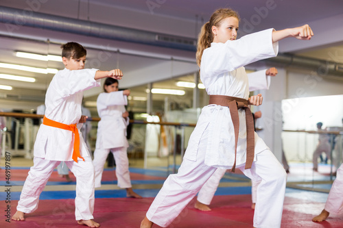 Sporty teenager children practicing new self defense moves in pairs at sport gym