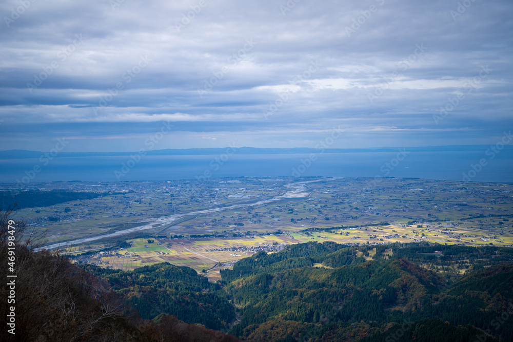 入善町、黒部宇奈月温泉や白馬岳を眺められる富山県入善町の負釣山を紅葉の時期に登山する風景 A view of climbing Mt.Oiturushiyama in Nyuzen-cho, Toyama Prefecture, with views of Kurobe Unazuki Onsen and Mt.Shirouma-dake, during the season of autumn