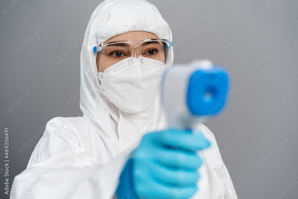 doctor in protective PPE suit scanning with infrared thermometer doctor in protective PPE suit scanning with infrared thermometer