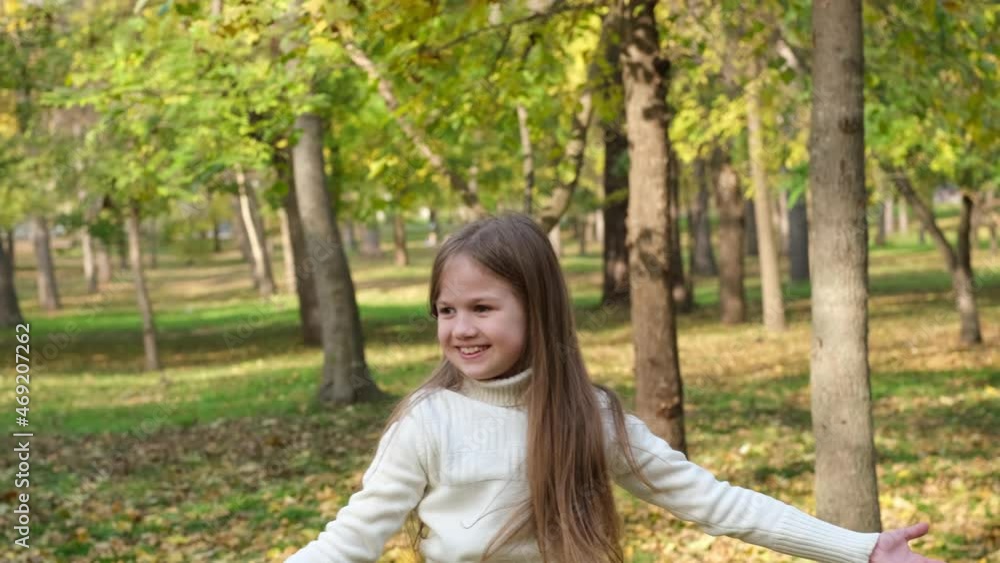 Girl playing with fall leaves in city park. Cute little blond child enjoying autumn. Kid having fun outdoors. Happy childhood. Closeup Girl playing with fall leaves in city park. Cute little blond child enjoying autumn. Kid having fun outdoors. Happy childhood. Closeup