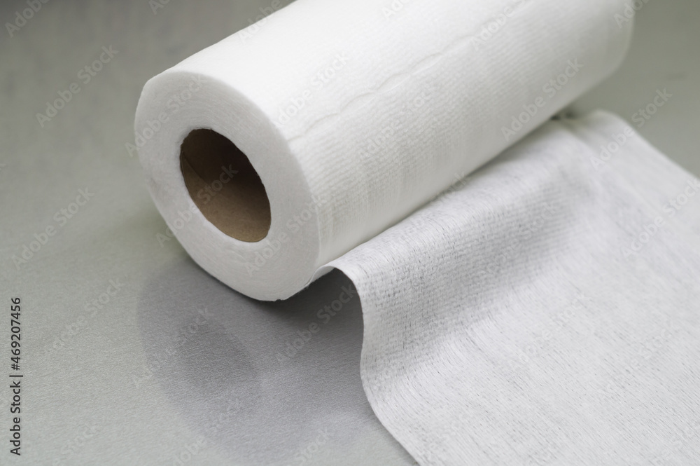Universal white fabric napkins for cleaning in a roll. Bobbin with napkins for dispenser. Selective focus Universal white fabric napkins for cleaning in a roll. Bobbin with napkins for dispenser. Selective focus
