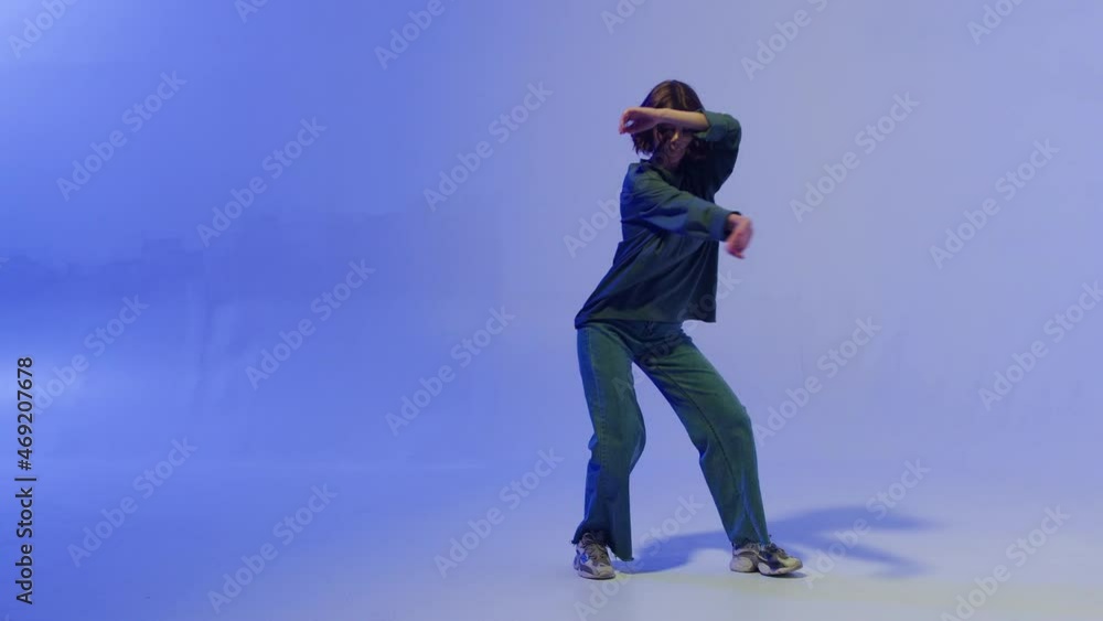 Woman dancing hip hop on colour changing neon background in studio. Modern choreography, dvertising of dance school, dancer expressing feelings for music video performance. Woman dancing hip hop on colour changing neon background in studio. Modern choreography, dvertising of dance school, dancer expressing feelings for music video performance.