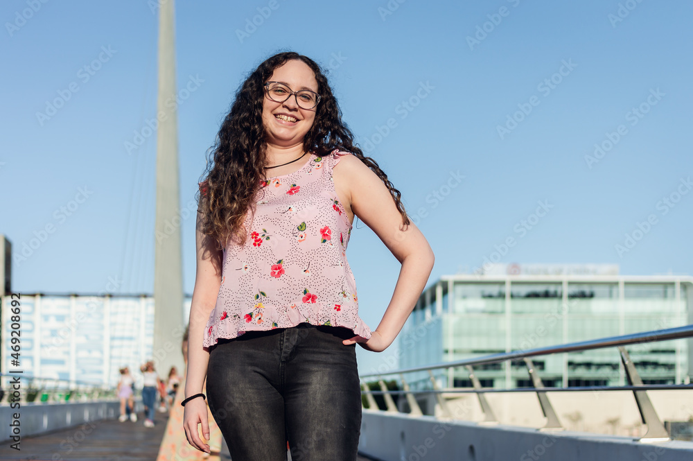 young latin girl with corrective lenses on a bridge posing and smiling in front of the camera young latin girl with corrective lenses on a bridge posing and smiling in front of the camera